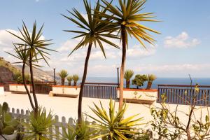 a view of the ocean from a resort with palm trees at Maison de Charme Taormina with private jacuzzi in Taormina