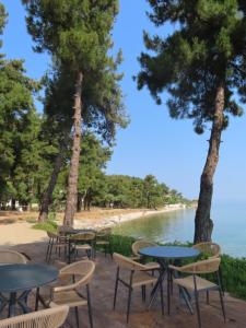 a row of tables and chairs next to a body of water at Aroma Beach Bungalows in Limenas