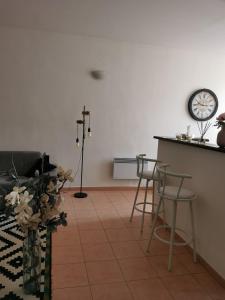 a living room with a counter and a clock on the wall at Appartement T2 centre-ville in Corte