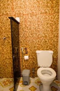 a bathroom with a white toilet in a tile wall at Pousada Vila Mundi Itaúnas in Itaúnas +17 photos