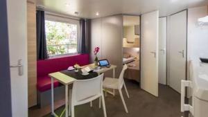 a room with a table with a laptop on it at Camping La Pinatelle in Saint-Auban +30 photos