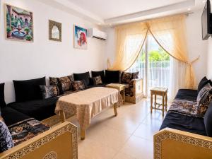 a living room with a couch and a table at Appartement standing terrasse privative et piscine - Kariat Cabo in Cabo Negro