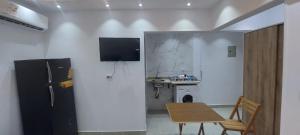 a small kitchen with a table and a refrigerator at Egy property in 6th Of October