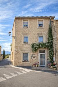 a large brick building with flowers on the windows at Provence Now in Cabrières-dʼAvignon