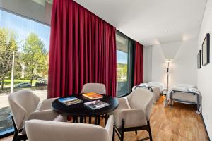 a room with a table and chairs and a bed at Axis Viana Business & SPA Hotel in Viana do Castelo