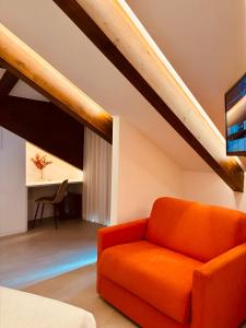 an orange couch in a room with a desk at Le Perseidi in Agerola