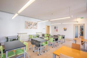 a classroom with tables and chairs in a room at HI Guimaraes - Pousada de Juventude in Guimarães