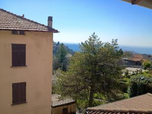 a view of a house and a tree from a building at Affascinante Mansarda nel Cuore di Brunate in Brunate
