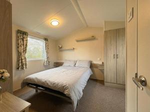 a bedroom with a bed and a window at Prime lakeside caravan at Haven Golden Sands in Mablethorpe