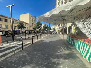 a street with a food stand with an umbrella at Un balcon sur la mer in Nice +7 photos
