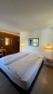 a bedroom with a large white bed in a room at Hotel Gran Baita in Gressoney-Saint-Jean +104 photos