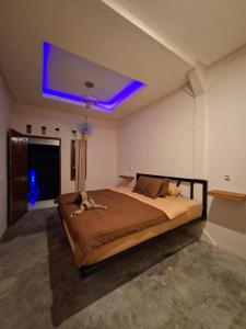 a bedroom with a large bed with a blue ceiling at Iza home stay in Senaru