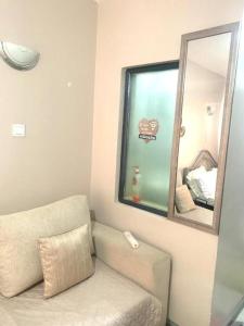 a living room with a couch and a mirror at Cozy Studio in Nairobi's Prime Location in Nairobi