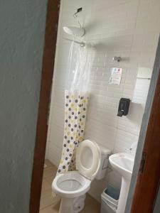 a small bathroom with a toilet and a sink at Ape Bianck's in Ilha Comprida