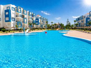 a large swimming pool in front of some apartment buildings at Appartement standing terrasse privative et piscine - Kariat Cabo in Cabo Negro