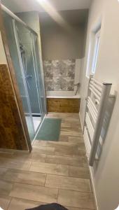 a bathroom with a shower and a tile floor at Maison de charme 3 chambres in Saligny-sur-Roudon