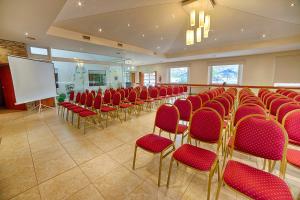 a conference room with red chairs and a whiteboard at Hotel Sol del Añelo in Añelo