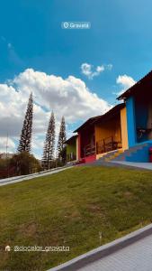 a building with a grassy yard next to some trees at Casa verde Recanto Doce lar in Gravatá