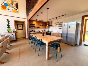 a kitchen with a table and chairs and a refrigerator at Casa 02 Monte Boa Vista - Casa de 4 Suítes com Vista Deslumbrante in Teresópolis