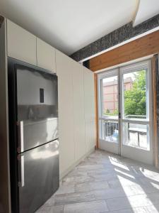 a kitchen with a stainless steel refrigerator and a window at Padova in Cedro in Padova +16 photos
