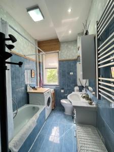 a bathroom with a tub sink and a washing machine at Padova in Cedro in Padova