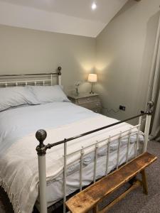 a bedroom with a bed and a wooden bench at 86 Galgorm in Ballymena +3 photos