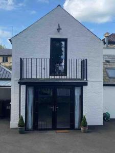 a white house with a balcony on top of it at 86 Galgorm in Ballymena