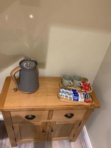 a wooden table with a tea kettle and cups on it at 86 Galgorm in Ballymena