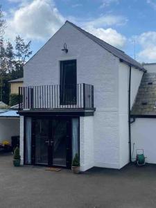 a white building with a balcony on top of it at 86 Galgorm in Ballymena