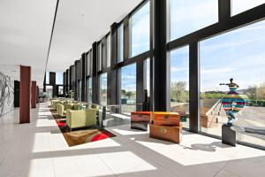 a lobby with large windows and a statue of a woman at Axis Viana Business & SPA Hotel in Viana do Castelo
