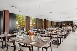 a dining room with tables and chairs and a restaurant at Axis Viana Business & SPA Hotel in Viana do Castelo