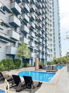 a hotel swimming pool with chairs and a building at Studio Unit in Manhattan Heights with Balcony in Sampong