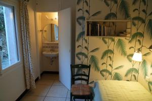 a bedroom with a bed and a bathroom with palm wallpaper at Maison vue mer exceptionnelle in Le Lavandou