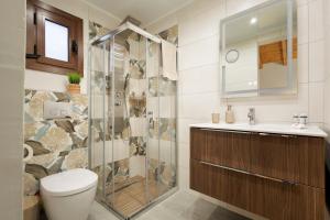 a bathroom with a shower and a toilet and a sink at Hidden Petra Luxury Suites 2 in Ialysos +19 photos
