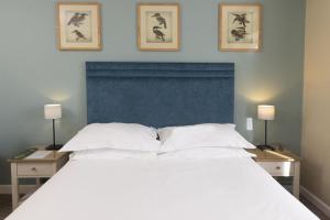 a bedroom with a large white bed with two night stands at The Bridge House; BW Signature Collection in Ferndown +111 photos