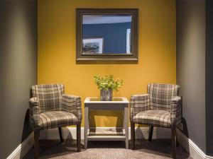 a room with two chairs and a table with a mirror at The Bridge House; BW Signature Collection in Ferndown