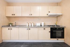 a kitchen with white cabinets and a stove top oven at Magnifique appartement 3 pièces à Hydra in Hydra