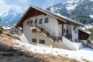 a building with snowy mountains in the background at Cesa del Volp in Canazei