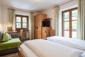 a hotel room with two beds and a tv at Baumgartnerhof in Lagundo