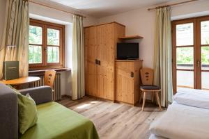 a hotel room with a bed and a tv at Baumgartnerhof in Lagundo