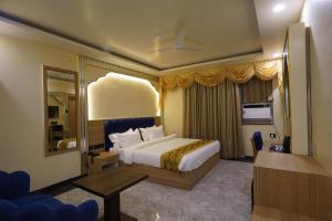 ein Hotelzimmer mit Bett und Spiegel in der Unterkunft PS Marriott Hotel in Patna