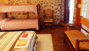 Habitación con cama, sofá y silla en Cabañas Altos del Velazco en La Rioja