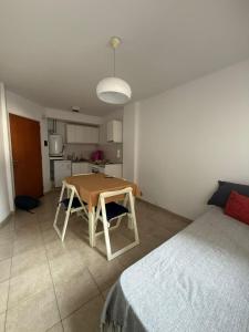 a room with a table and a bed and a kitchen at Studio Roca in Rosario