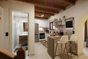 a kitchen with a counter and two stools at Hidden Petra Luxury Suites 2 in Ialysos