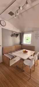 a room with a bed and a table and chairs at Mobilheim Coco in Biograd na Moru