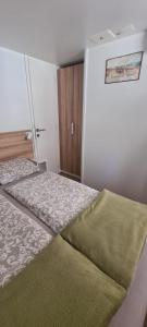 a small bedroom with a bed and a wall at Mobilheim Coco in Biograd na Moru +19 photos