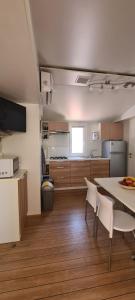 a kitchen with a table and chairs in a room at Mobilheim Coco in Biograd na Moru