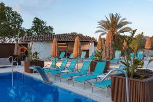a row of chairs next to a swimming pool at Bahía de Alcudia Hotel & Spa in Port d'Alcudia