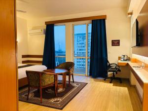 a hotel room with a bed and a desk and a table at Golden Pent House in Lucknow +29 photos