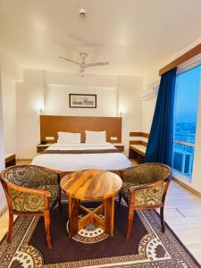 a bedroom with a bed and a table and chairs at Golden Pent House in Lucknow